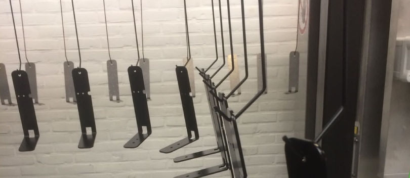 Zwarte L-vormige speaker beugels aan een productielijn